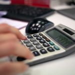 Main tapant sur une calculatrice avec un écran numérique
