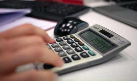 Main tapant sur une calculatrice avec un écran numérique