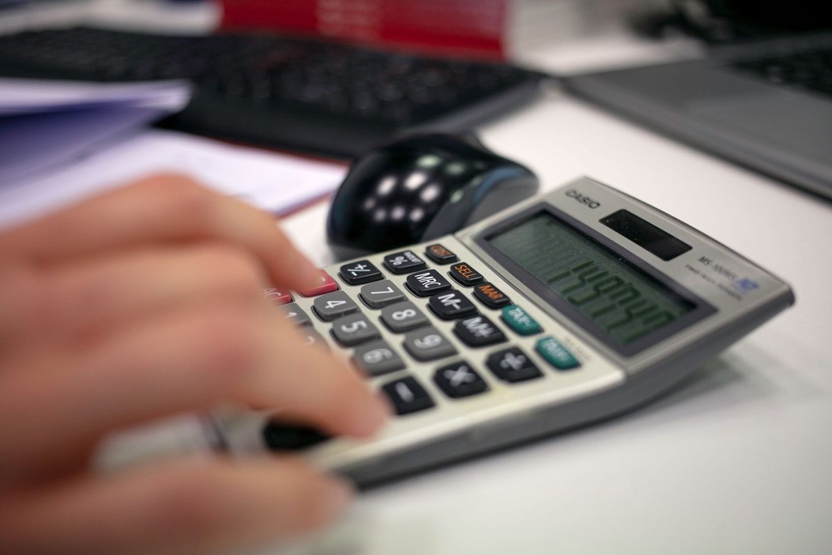 Main tapant sur une calculatrice avec un écran numérique