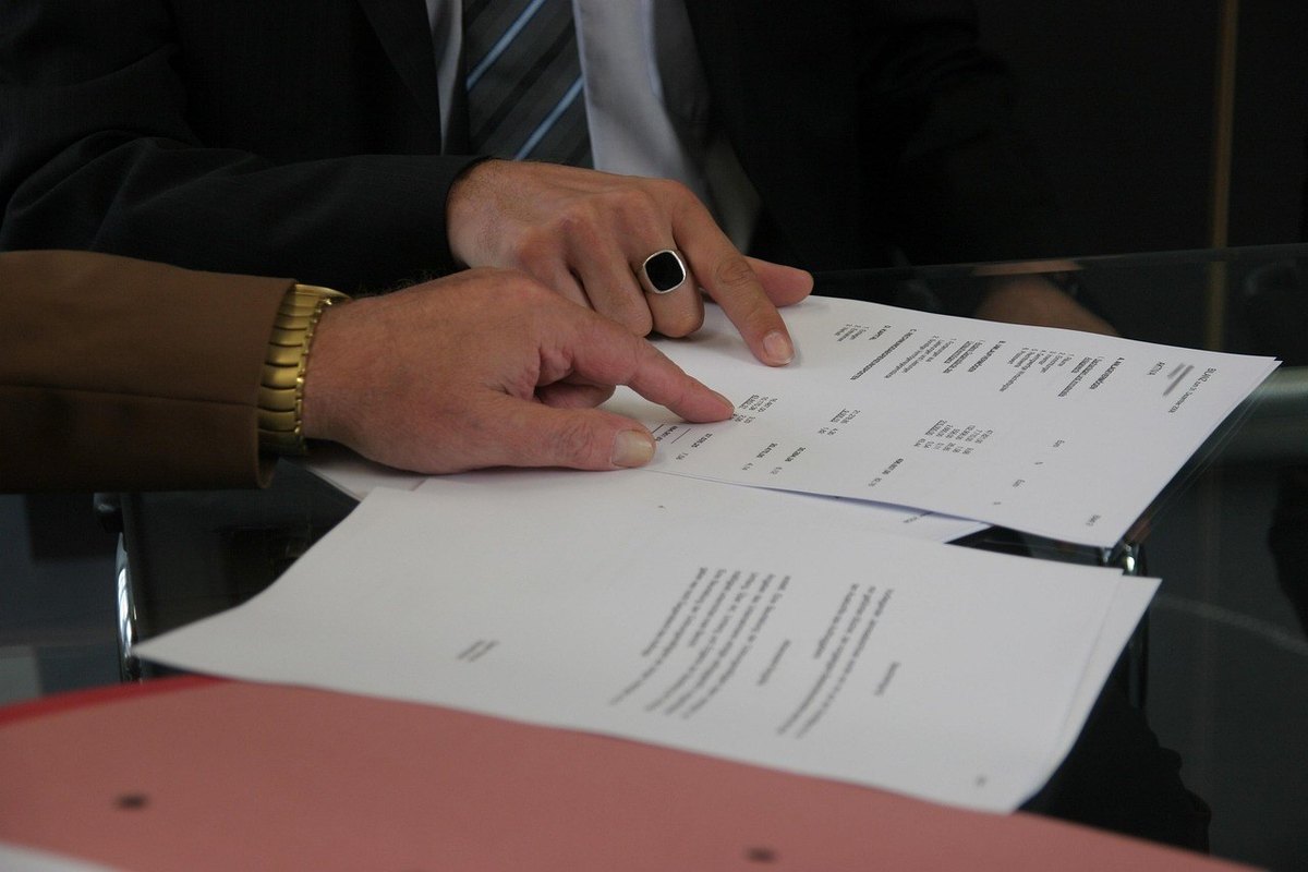 Mains sur des papiers, montre et anneau noir, réunion professionnelle Mains sur des papiers, montre et anneau noir, réunion professionnelle