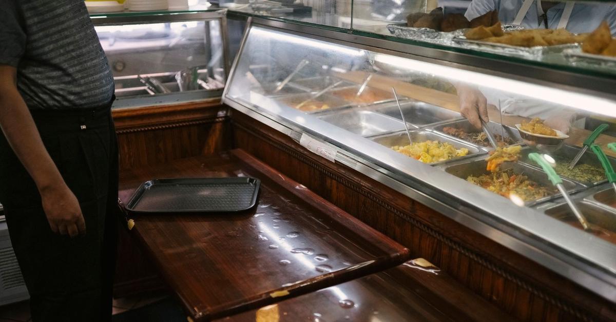 Buffet de nourriture avec platines et ustensiles sous éclairage fluorescent