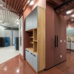 Espace de travail moderne avec cuisinette intégrée, mobilier design et cloisons vitrées