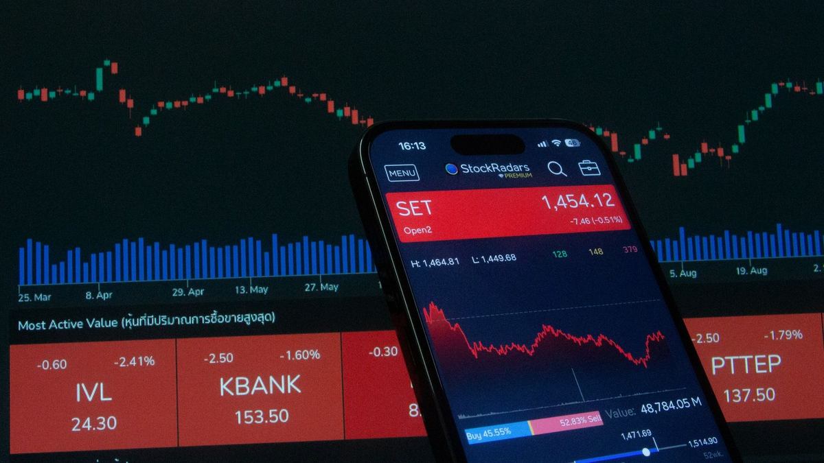 Smartphone montrant des graphiques boursiers avec des barres colorées et des chiffres en rouge