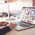 Une personne utilise un ordinateur portable affichant des images sur une table