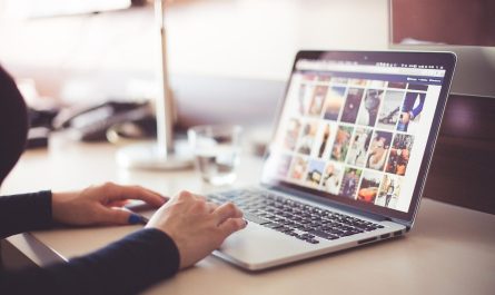 Une personne utilise un ordinateur portable affichant des images sur une table